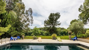 A swimming pool with blue lounge chairs and potted plants around it. - Flat in a beautiful building with pool (Mèze)