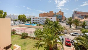 A residential area with a swimming pool, palm trees, and a variety of buildings including a modern structure with a glass facade. - Roquetas Beachside Getaway (Roquetas del Mar)
