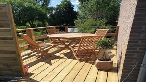 A wooden deck with a table and chairs, surrounded by a wooden fence. - Cottage in Aywaille with Garden (Aywaille)