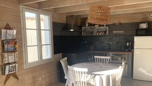 A cozy kitchen with a dining area, wooden walls, a large window, and a 'BIENVENUE' sign. - ELOISE             . (Sainte-Marie-de-Ré)