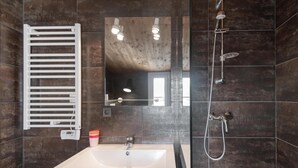A modern bathroom with a large mirror, a white sink, a handheld showerhead, and a towel rack. - ELOISE             . (Sainte-Marie-de-Ré)