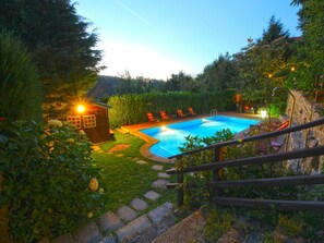Relax by the pool surrounded by lush greenery and lounge chairs.