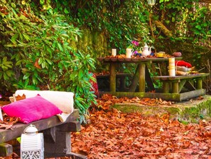 Enjoy a serene picnic amidst the natural beauty of our outdoor setting, complete with a cozy bench and a charming tea service.