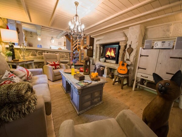 Cozy living room with a fireplace, comfortable seating area, and a guitar.
