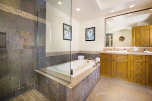 A modern bathroom with a glass-enclosed shower, a freestanding bathtub, wooden cabinets, and a large mirror. - Bachelor Gulch Village (Avon)