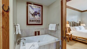 A bathroom with a bathtub, a shower, and a poster on the wall.