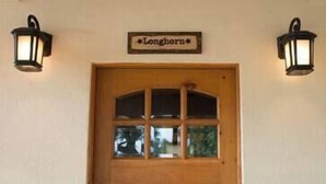 Puiset ovet, joissa on lasiruutu, ja niiden yläpuolella oleva kyltti, jossa lukee ”Longhorn”.
