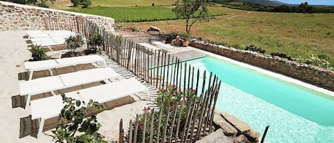 A heated pool, sun loungers