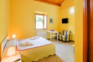 Una habitación de hotel con cama, escritorio, silla y sofá.