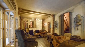 Amplia sala de estar con piso de madera, una escalera y un comedor con mesa y sillas.