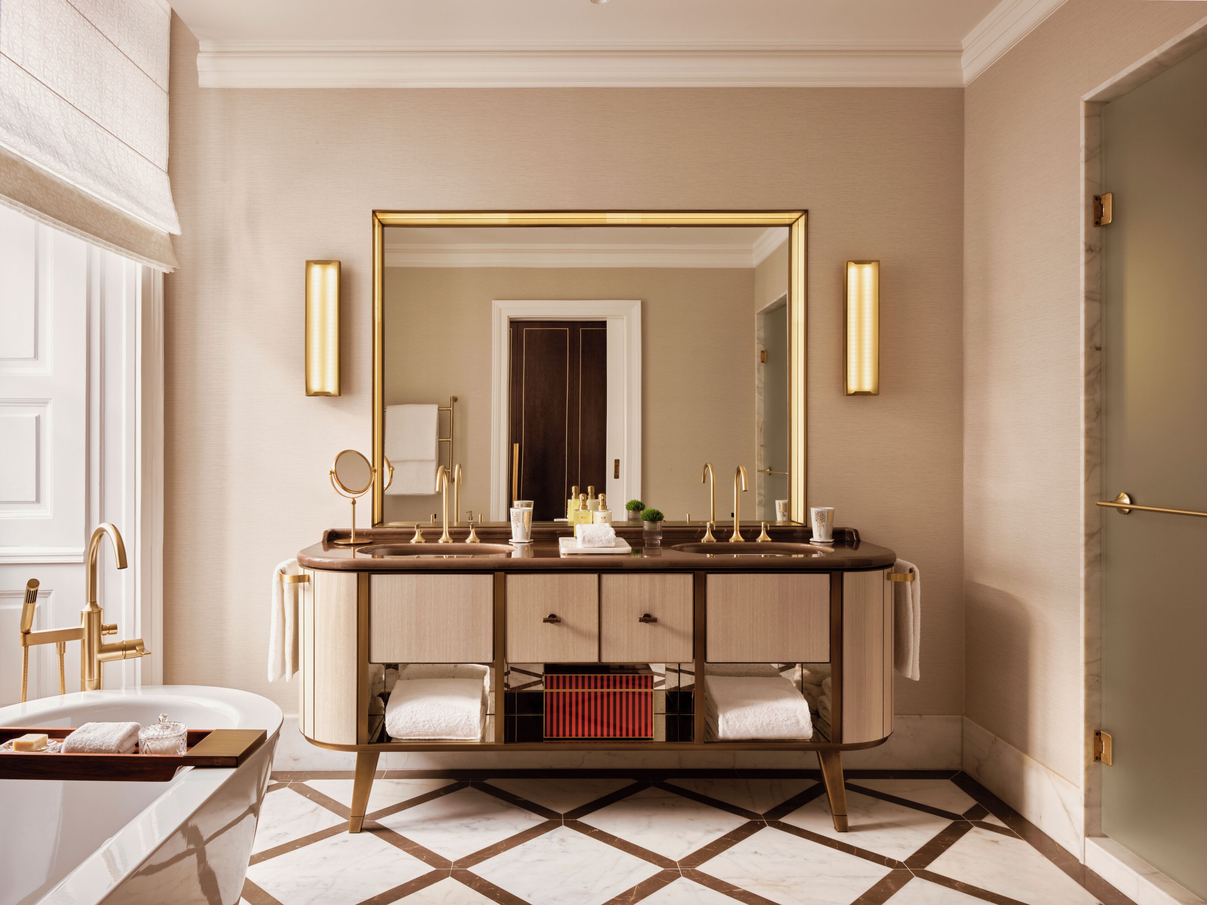 A modern bathroom with a double vanity, a large mirror, and a bathtub.