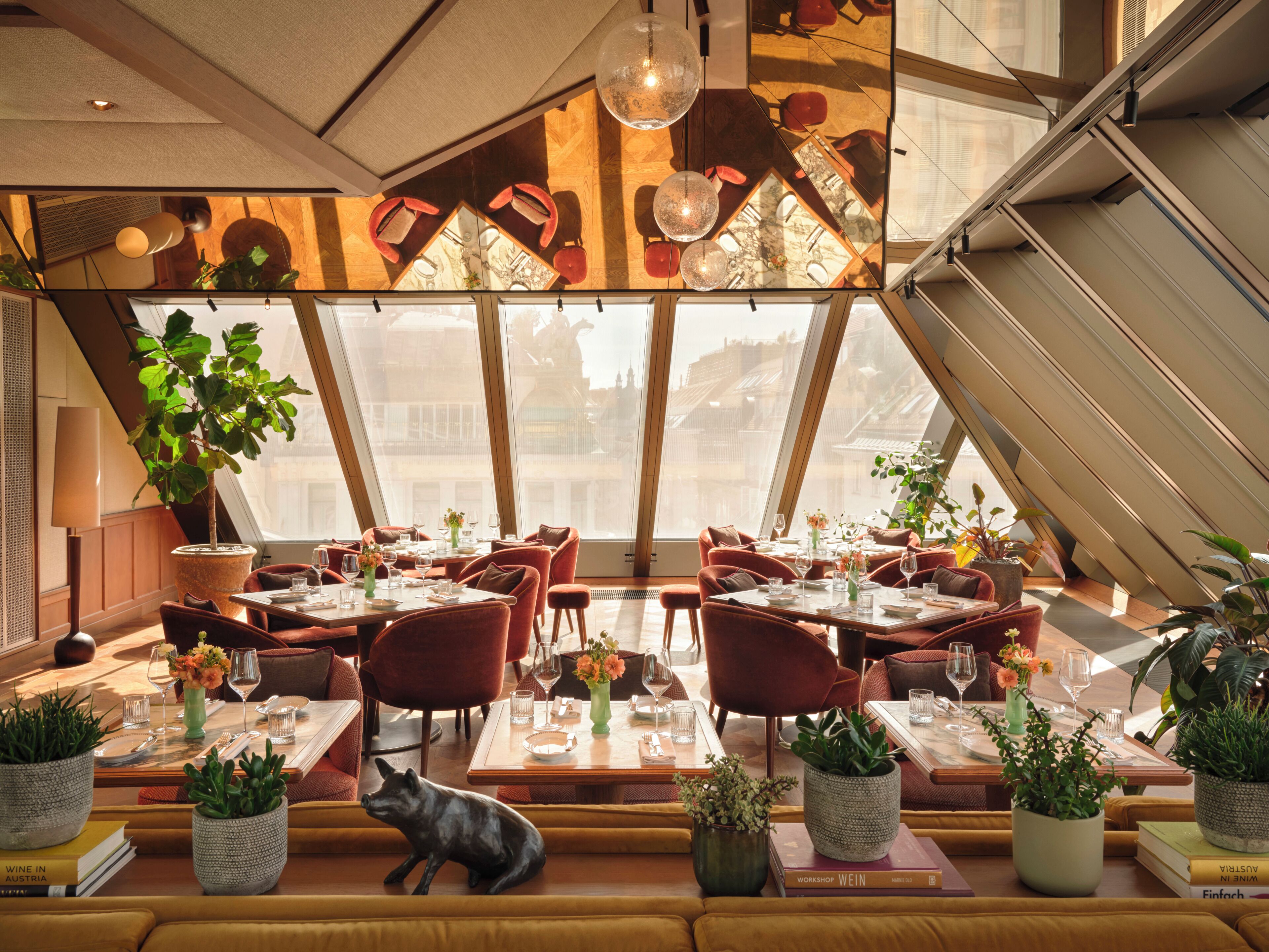 A restaurant with multiple dining tables, chairs, and potted plants.