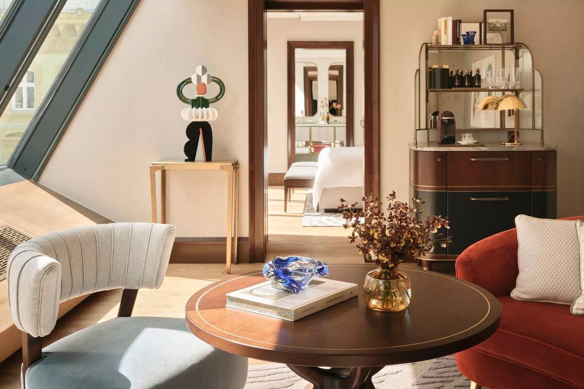 A modern living room with a red sofa, a round coffee table, and a bookshelf.