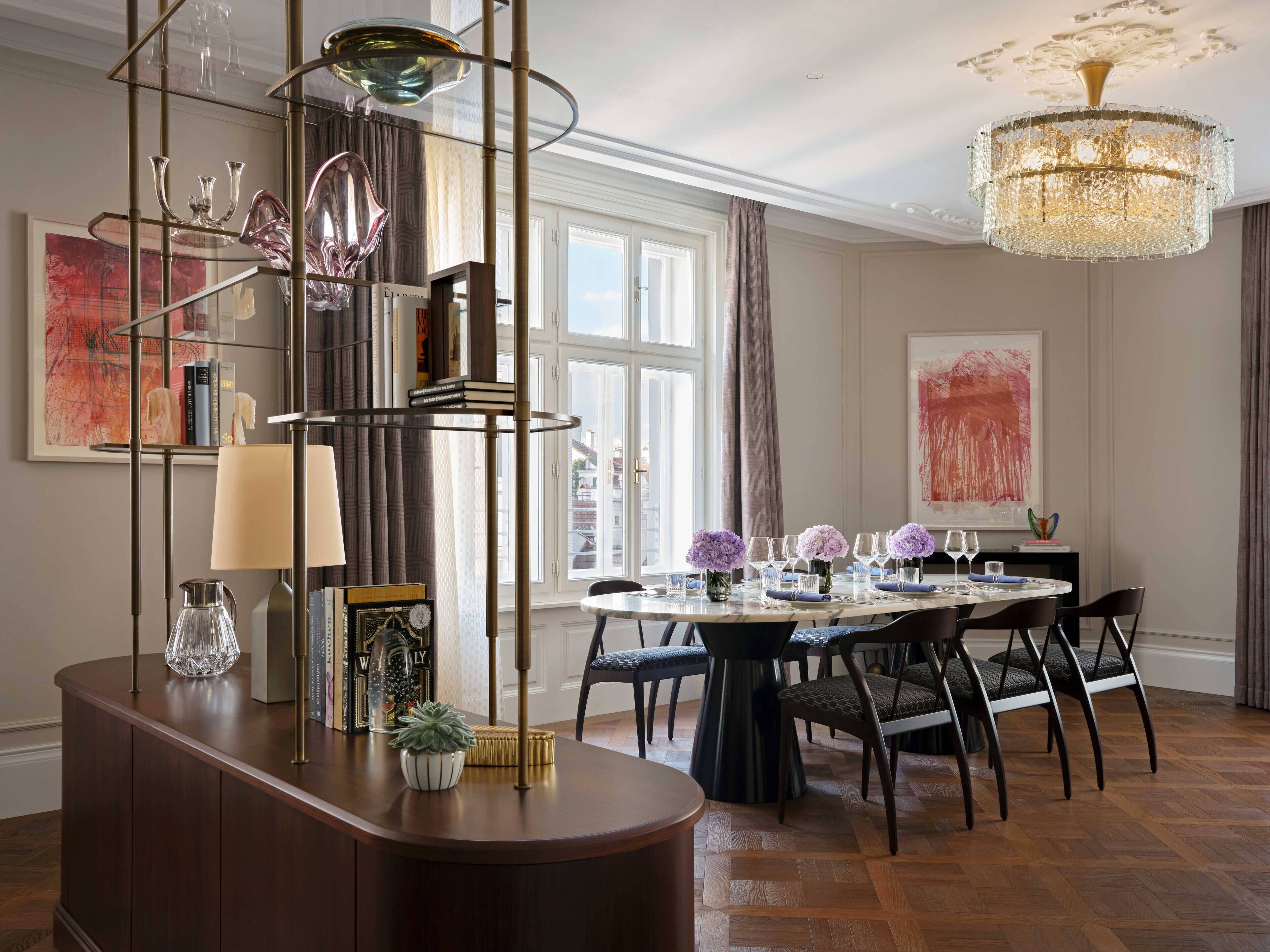 A dining area with a round table set for six, surrounded by six chairs.