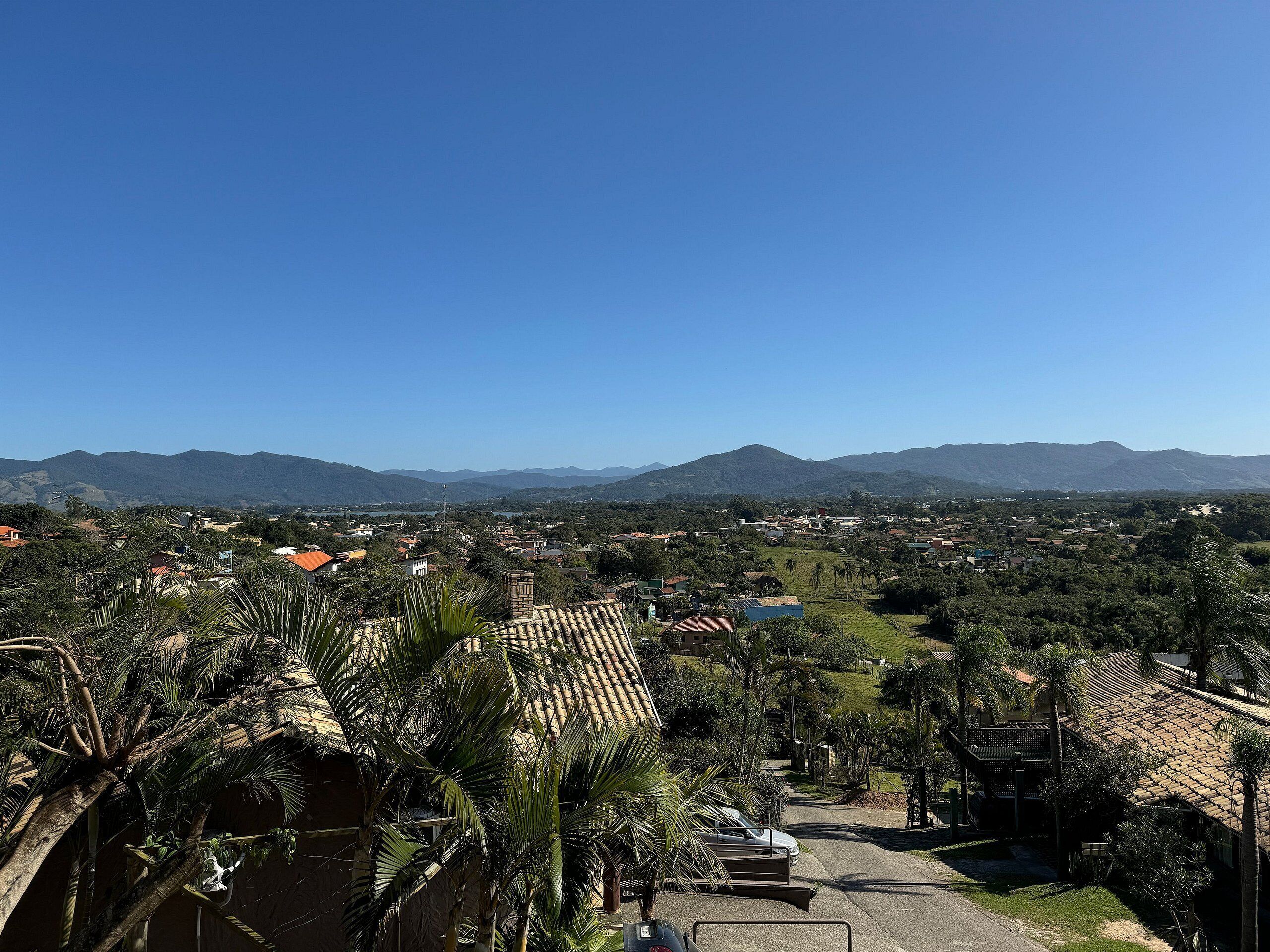 Zona residencial con casas, palmeras y montañas al fondo.