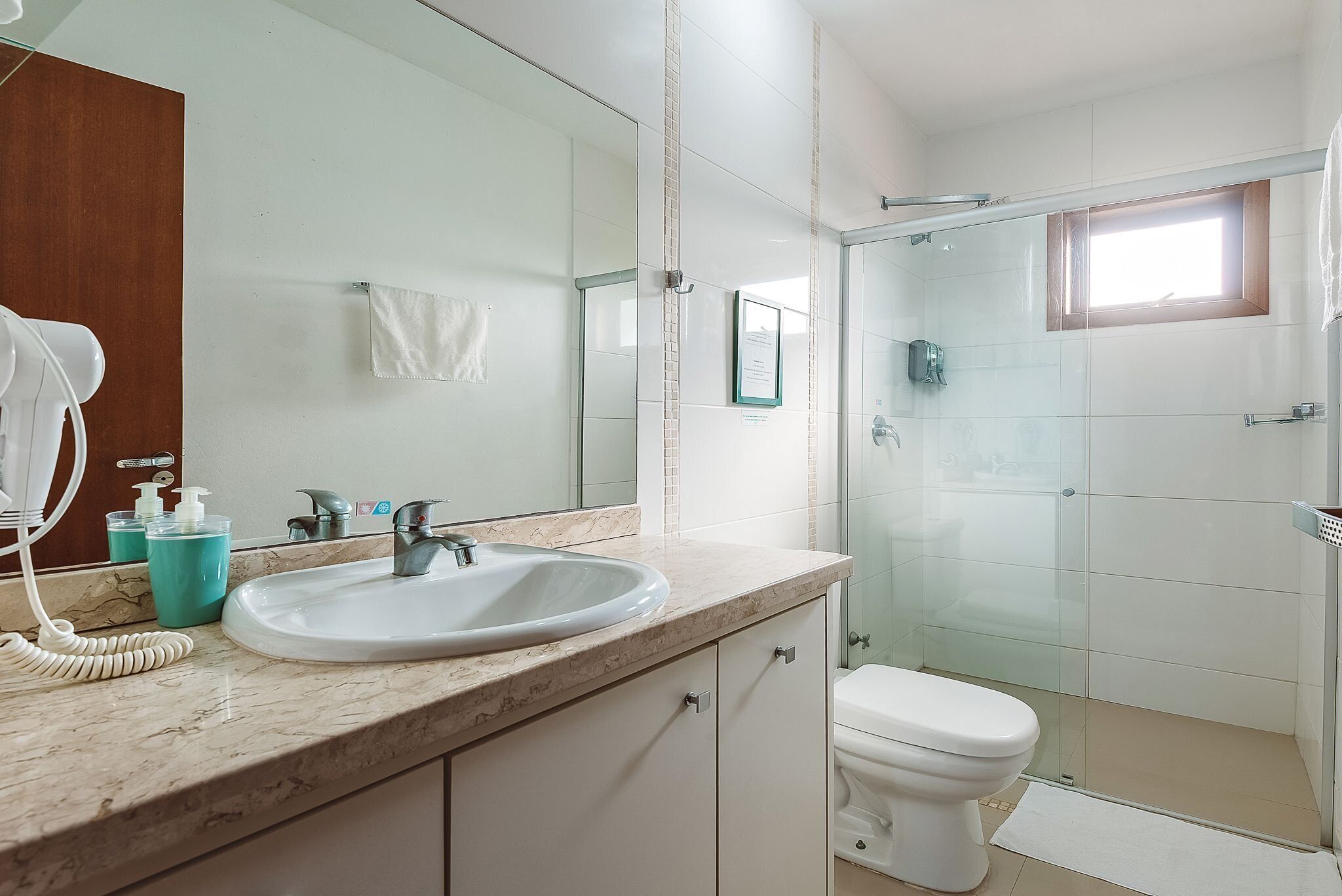 A bathroom with a sink, mirror, and toilet.