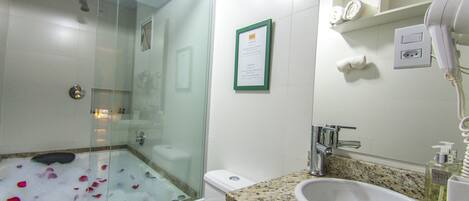 Ein Badezimmer mit Duschkabine, Waschbecken und Spiegel.