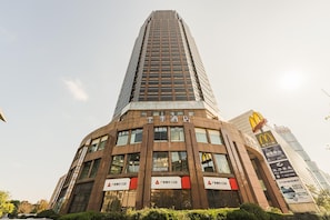 A tall building with multiple signs, including '金陵酒店' and '广发银行 CGB'. - Ji Hotel (Shanghai)