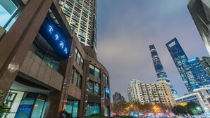 A modern high-rise building with a prominent sign indicating a hotel.