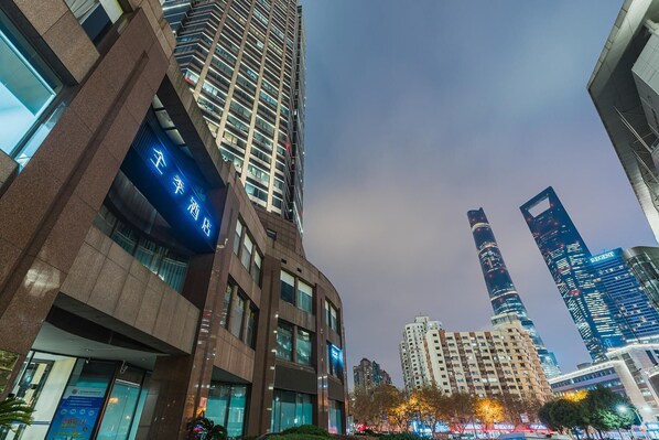 A modern high-rise building with a prominent sign indicating a hotel.