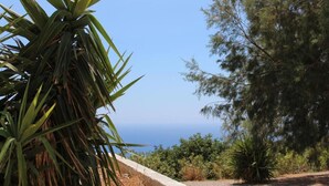 A coastal landscape with a clear view of the sea, surrounded by dense greenery and trees. - Paterakis Big Studio in Triopetra (Agios Vasileios)
