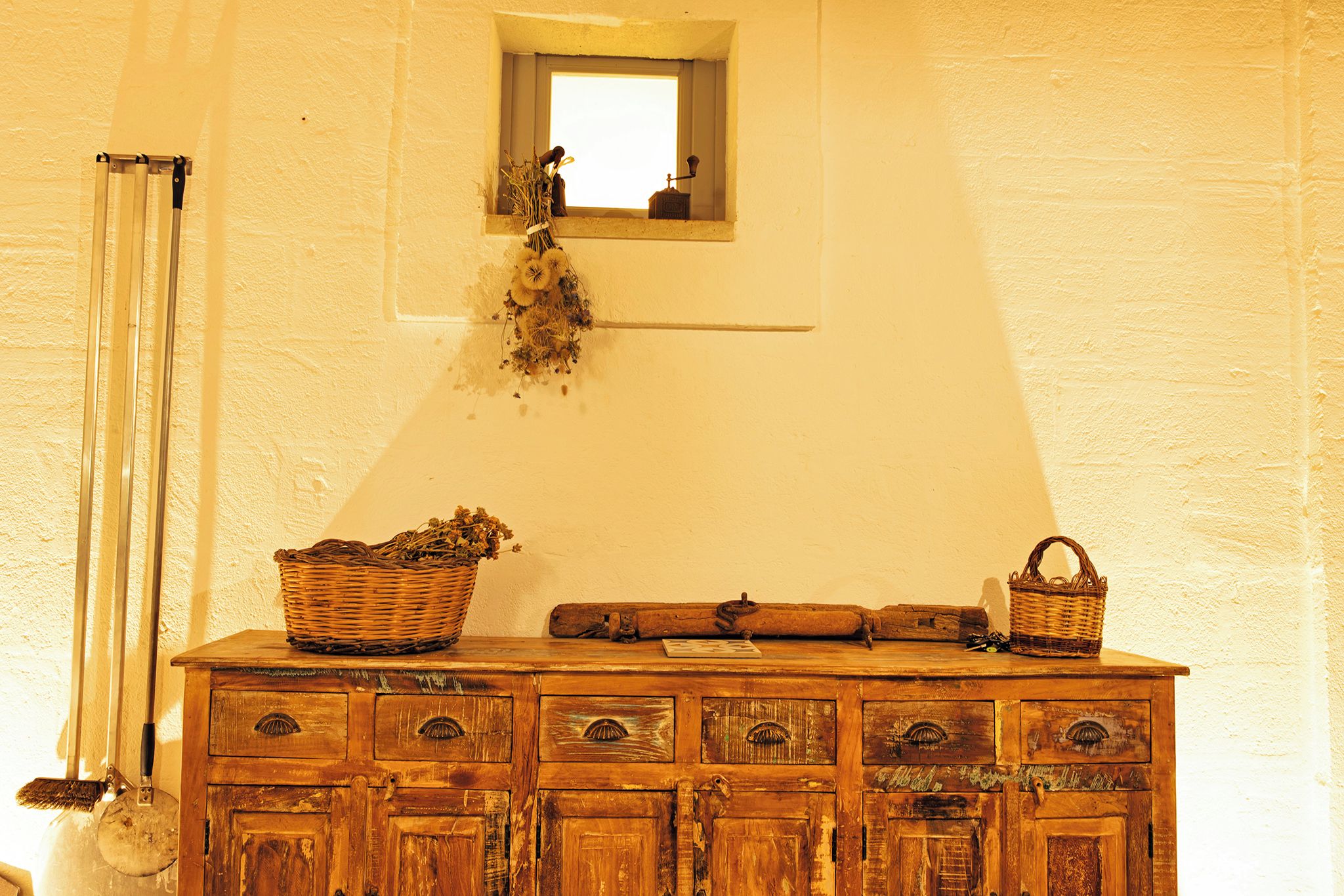 Une commode en bois avec des tiroirs, un miroir et des paniers posés sur le dessus.