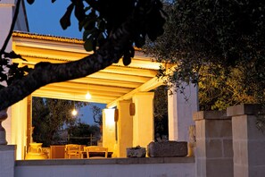 An outdoor patio area with a pergola, stone columns, and a table and chairs. - Masseria Ferarelli Trepizzi (Diso)