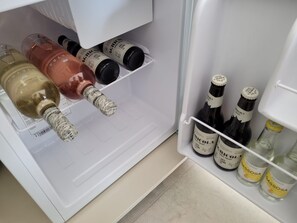 A refrigerator with bottles of alcohol, including a bottle of wine and several bottles of whiskey. - Masseria Ferarelli Trepizzi (Diso)