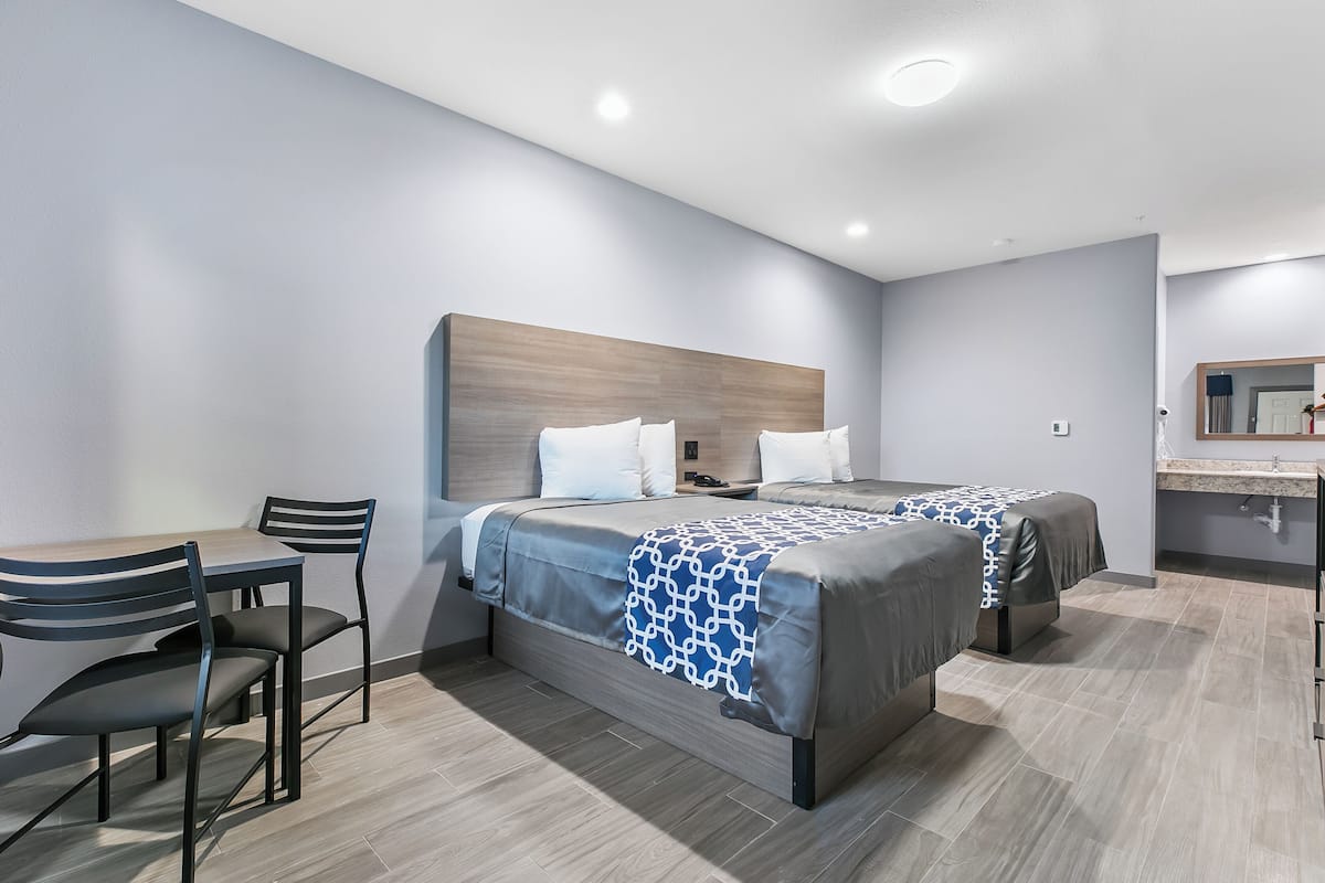 Una habitación de hotel moderna con dos camas, un escritorio y una silla.
