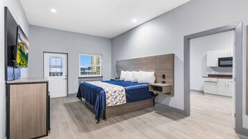 Relax in this serene bedroom with a large bed, flat-screen TV, and a view of the outdoors.