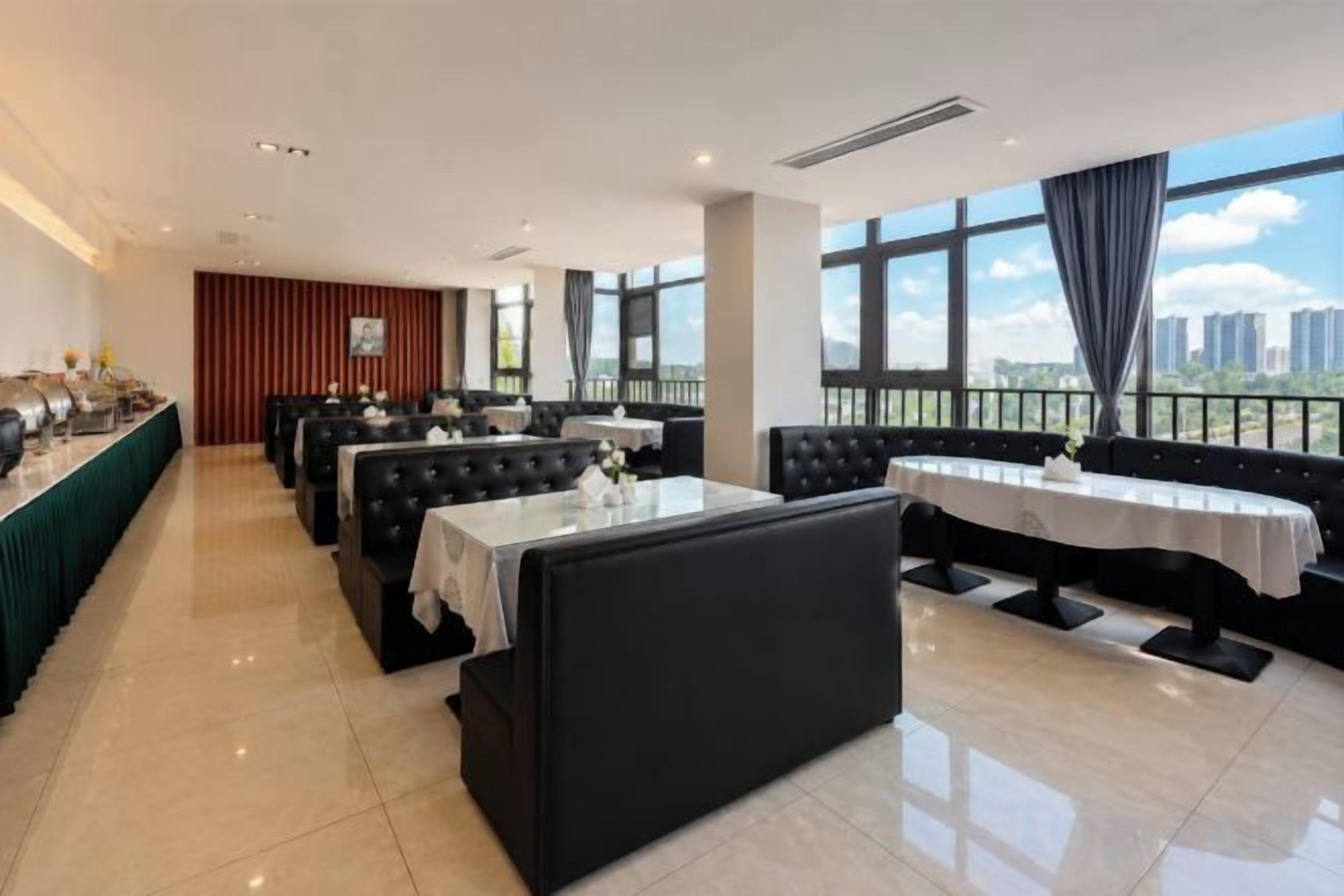 A restaurant with a long table and booths, large windows with a city view, and a modern interior design.
