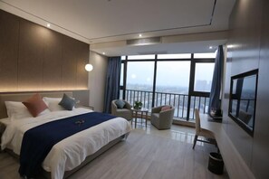 A modern hotel room with a large bed, a balcony with a view, a small table, and a TV. - Shimanting Hotel (Lingbi)