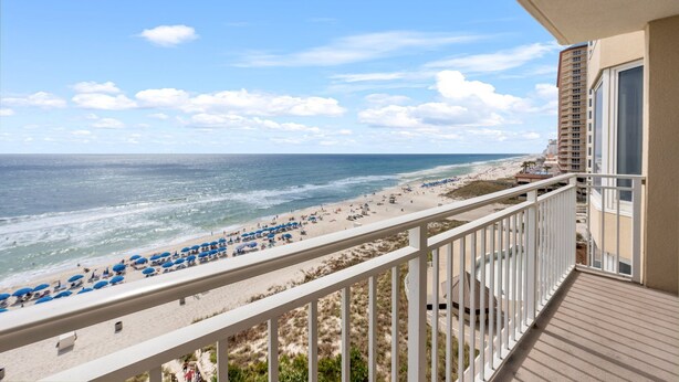 A balcony with a view of a beach and ocean.