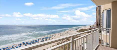 A balcony with a view of a beach and ocean.