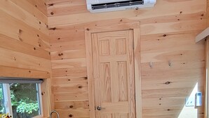 Una cocina compacta con paredes de madera, un lavamanos empotrado y una estufa blanca.