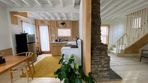 A spacious kitchen with a central island, a dining area with a wooden table and chairs, and a staircase leading to an upper level. - Modern Cottage 1 (The Lorca, Catskills) - 10 min to Belleayre, 25 min to Windham (Shandaken)