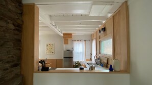 A modern kitchen with wooden cabinets, a stainless steel refrigerator, and a window providing natural light. - Modern Cottage 1 (The Lorca, Catskills) - 10 min to Belleayre, 25 min to Windham (Shandaken)