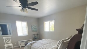 A bedroom with a bed, a ceiling fan, a window, and a chair. - Big Green House 4bdrm - 3 bath with Pool Table (Templeton)