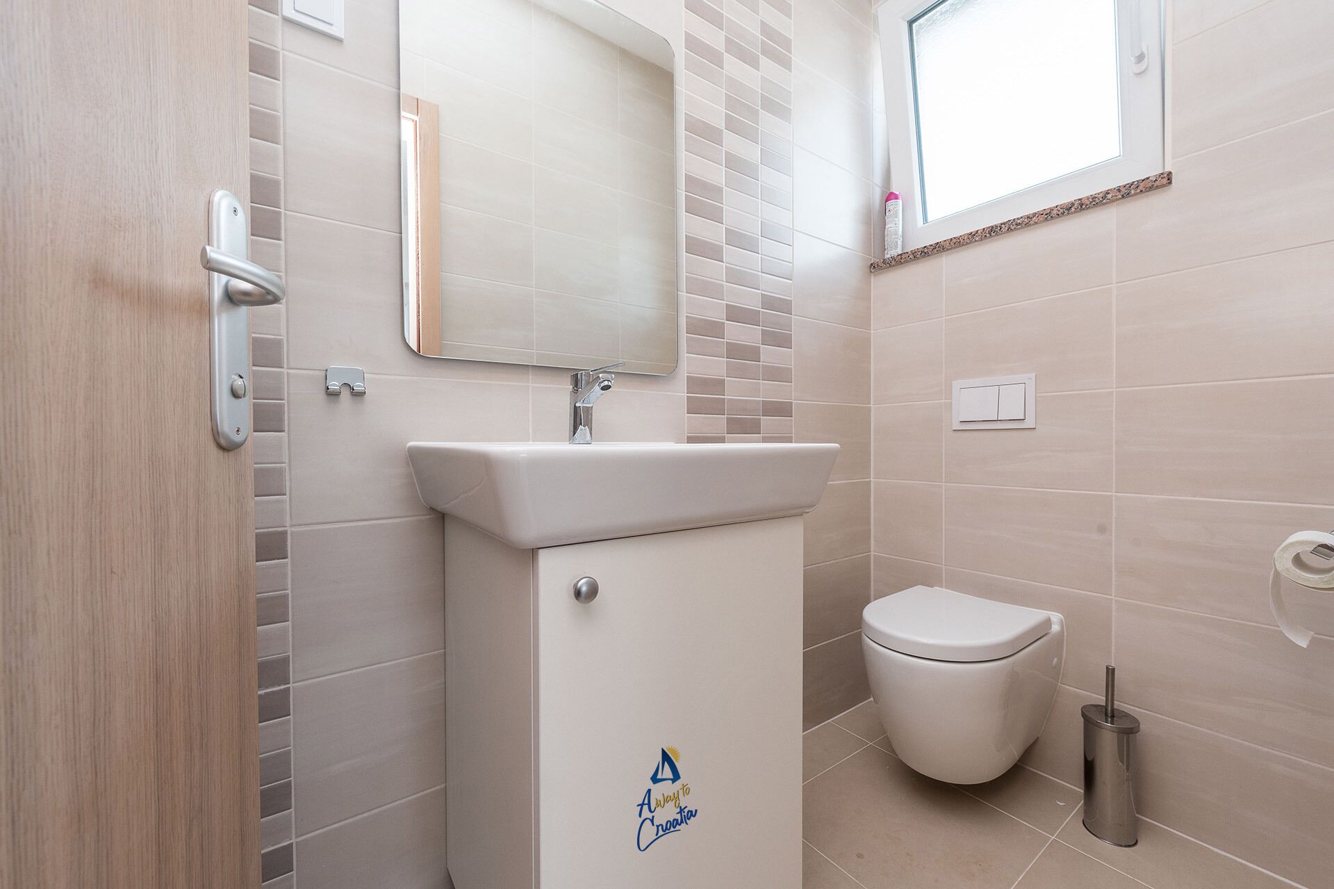 A bathroom with a white sink, a toilet, and a mirror.