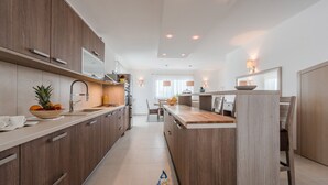 A modern kitchen with wooden cabinets, stainless steel appliances, and a central island. - Modern 4 BD villa with heated pool for up to 8 guests (Sukošan)