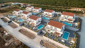 A modern residential area with multiple houses, each featuring a swimming pool and a patio area. - Modern 4 BD villa with heated pool for up to 8 guests (Sukošan)