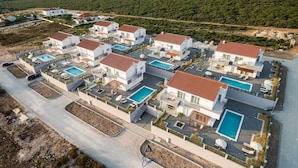 A modern residential area with multiple houses, each featuring a swimming pool and a patio area. - Exquisite 4 BD villa for 8 with heated pool near Zadar (Sukošan)