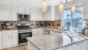 A modern kitchen with white cabinets, granite countertops, stainless steel appliances, and pendant lighting. - Perfect Las Vegas Private Retreat w/ Pool & Spa! (Las Vegas)