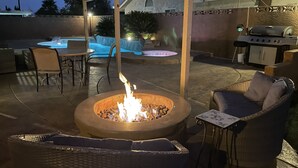 An outdoor patio with a fire pit, seating, and a barbecue grill. - Perfect Las Vegas Private Retreat w/ Pool & Spa! (Las Vegas)