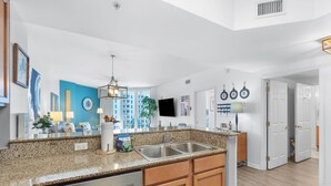 A modern kitchen with granite countertops, stainless steel appliances, and wooden cabinets. - 2705 Gulf Views ~ Super Deal ~ Heated Pool ~ Resort Bar, Hot Tub ~ Book Sept 7th (Destin)