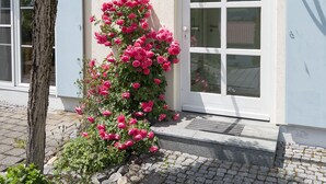 Ein Gebäude mit weißer Fassade, einer Tür mit Glasfeldern und einem Schild darüber.