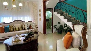 Una sala de estar amplia con un sofá, una mesa de centro y una escalera que lleva a un balcón.
