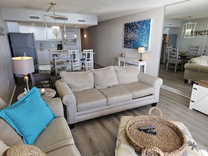 Relax in this stylish living space with a comfortable sofa, dining area, and fully equipped kitchen.