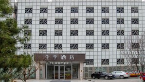 A hotel building with a grid-like facade, multiple windows, and a sign reading "JIHOTEL". - Ji Hotel (Beijing)