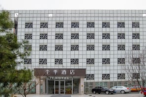 A hotel building with a grid-like facade, multiple windows, and a sign reading "JIHOTEL". - Ji Hotel (Beijing)